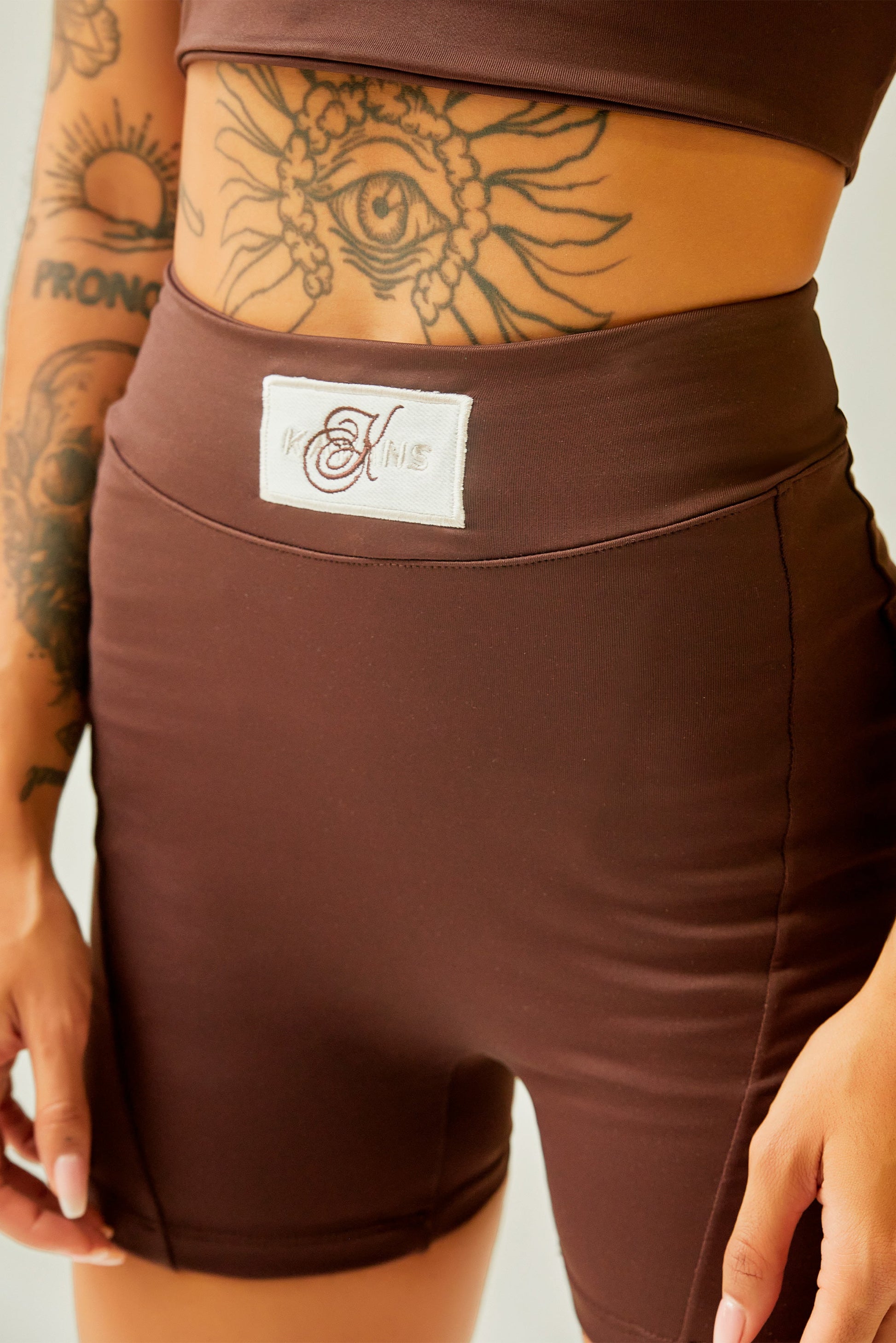 Biker deportivo chocolate con cortes y aplique Kavans